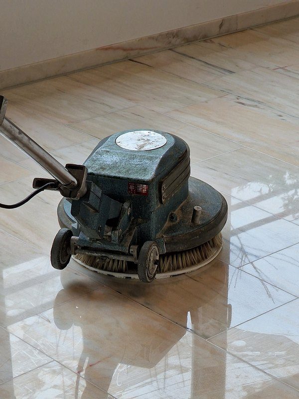 Einscheibenmaschine reinigt einen glänzenden Steinplattenboden